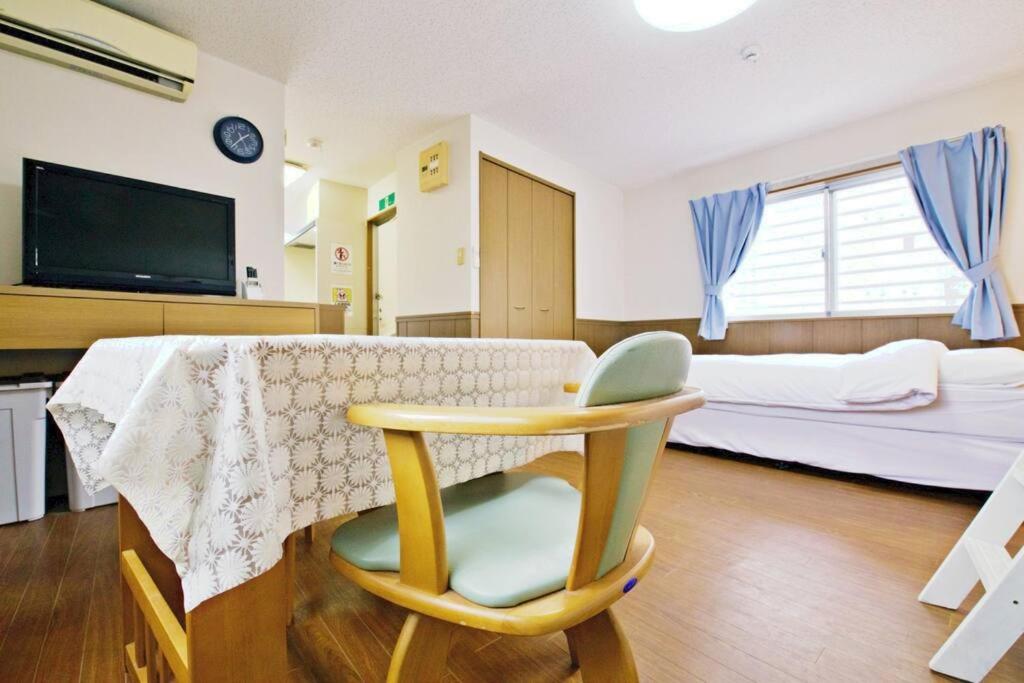 um quarto com uma mesa, uma cadeira e uma cama em ピースリー安里201 em Tomari
