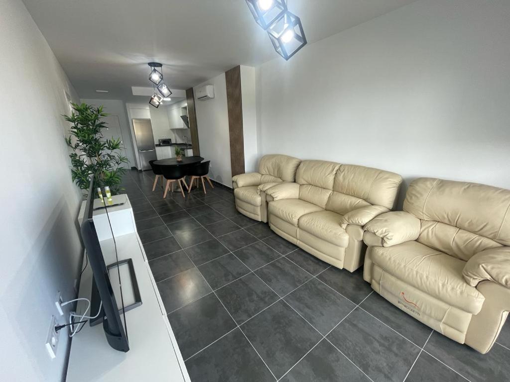 ein Wohnzimmer mit einem Sofa und einem Tisch in der Unterkunft Apartamento Luli in Calpe
