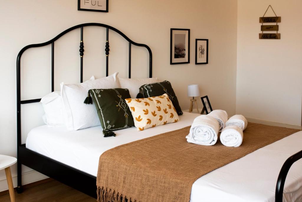 una camera da letto con un letto bianco e nero con asciugamani di Oporto Trindade Residence a Porto