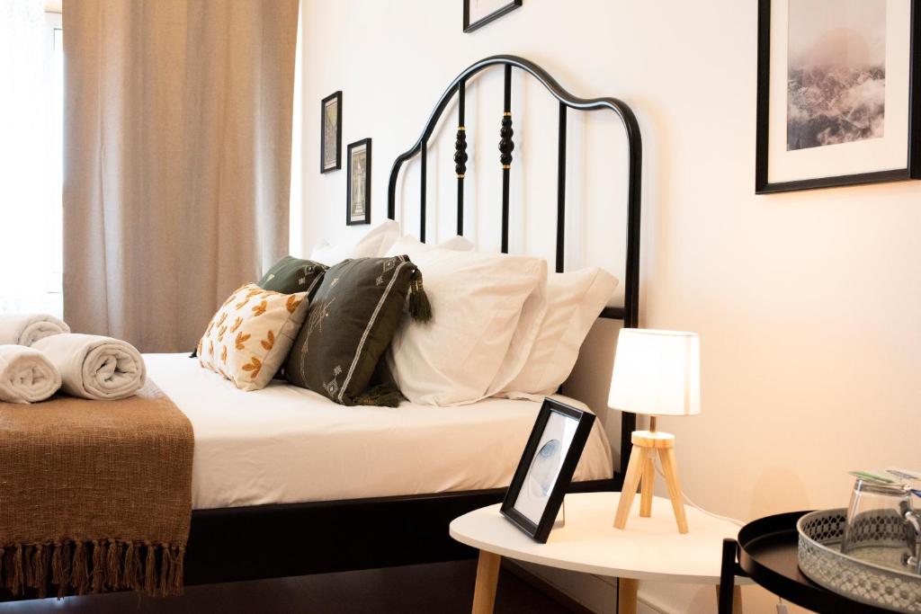 a bedroom with a bed with pillows on it at Oporto Trindade Residence in Porto