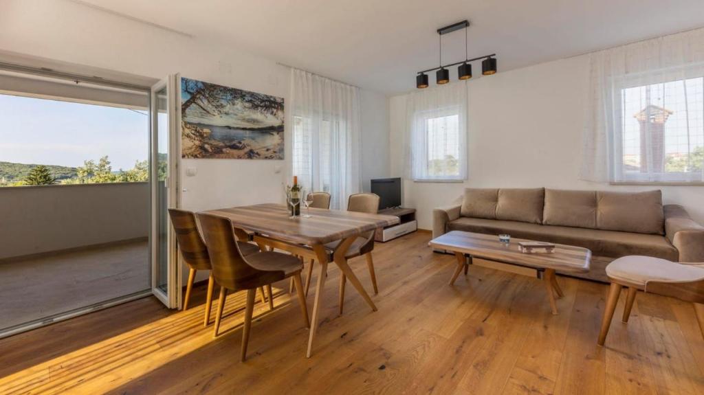a living room with a table and a couch at Beautiful new Apartment Ancora 2 in Nerezine