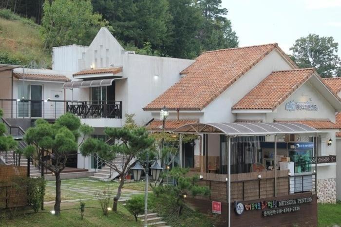 una gran casa blanca con techo en Meteora Pension, en Damyang