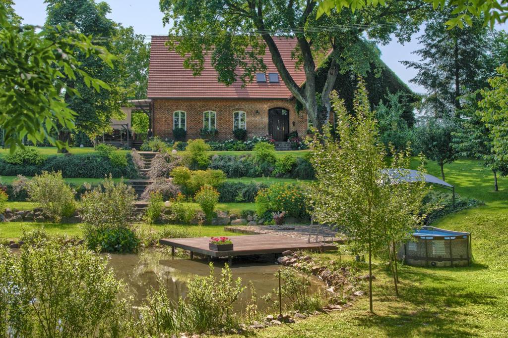 a garden with a house in the background at Stara Szkola Trzcin 20 in Trzcin