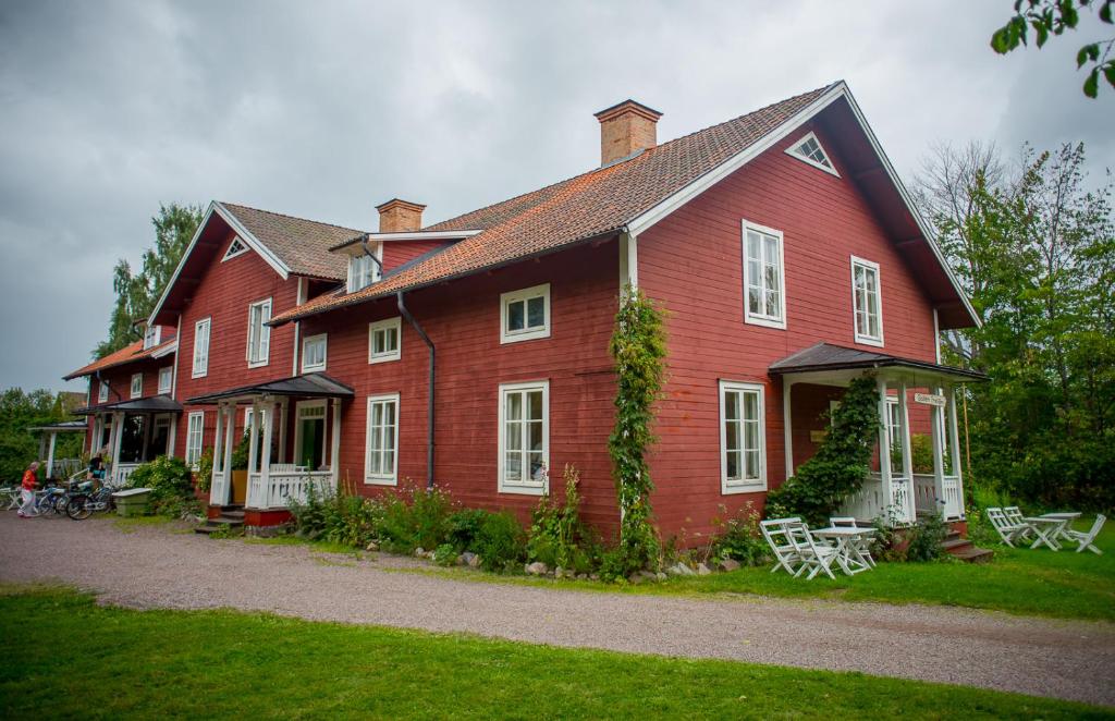 Stjärnsund的住宿－Fridhem，一间红色的大房子,设有白色的窗户