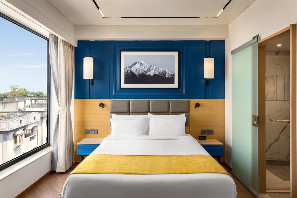 Postel nebo postele na pokoji v ubytování Ramada Encore by Wyndham Siliguri Sevoke Road