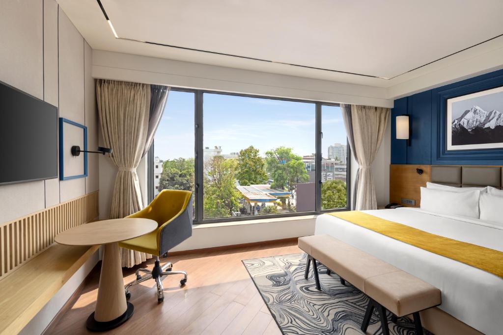Postel nebo postele na pokoji v ubytování Ramada Encore by Wyndham Siliguri Sevoke Road