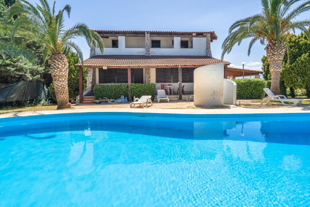 a large swimming pool in front of a house at Bes Beach - Villa con piscina in Fontane Bianche