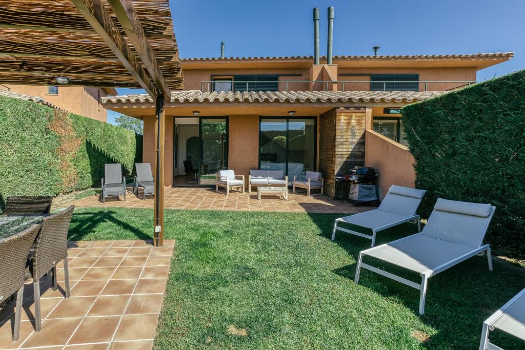 un patio avec des chaises et un barbecue dans une cour dans l'établissement Villa Brenda Torremirona Resort, à Navata