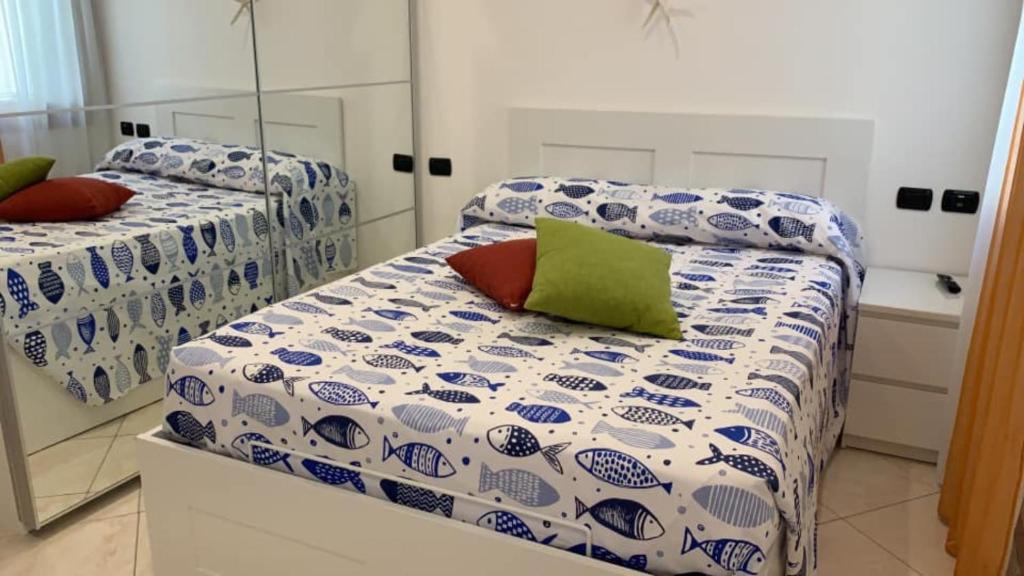 een slaapkamer met 2 bedden en een spiegel bij La Casa di Ines in Chioggia