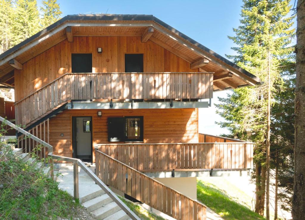 Cette maison en rondins comprend une terrasse et des escaliers. dans l'établissement Apartment MOUNTAIN BLOOM Golte, à Mozirje