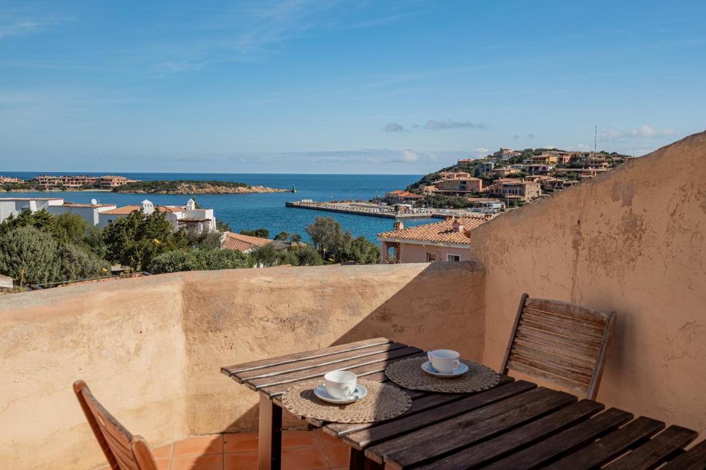 een tafel en stoelen op een balkon met uitzicht op de oceaan bij Casa Silvana by Wonderful Italy in Porto Cervo