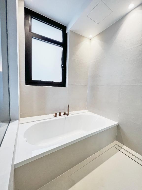 a white bath tub in a bathroom with a window at Casa Indiana Hotel Boutique in Blanes