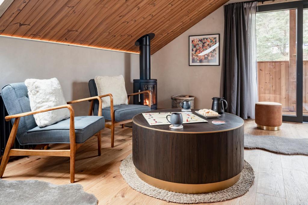 een woonkamer met een salontafel en stoelen bij Osprey Lodge in Aviemore