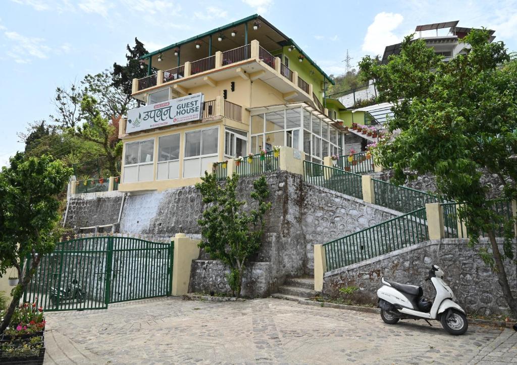 een scooter geparkeerd voor een gebouw bij Upvan Guest House and Residence in Bhīm Tāl