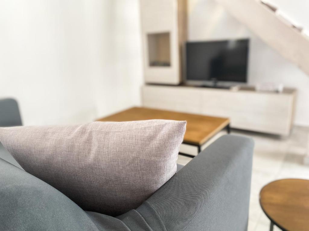 ein Sofa mit einem weißen Kissen im Wohnzimmer in der Unterkunft La Casetta - Appartamento Centro Storico Albenga in Albenga