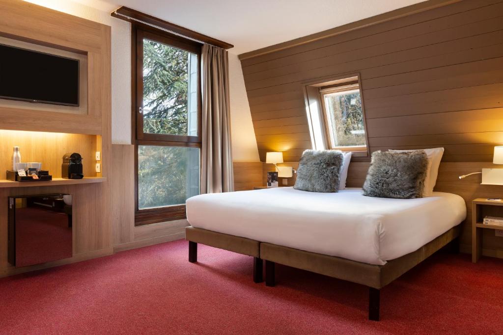 Postel nebo postele na pokoji v ubytování SOWELL HOTELS Mont Blanc et SPA