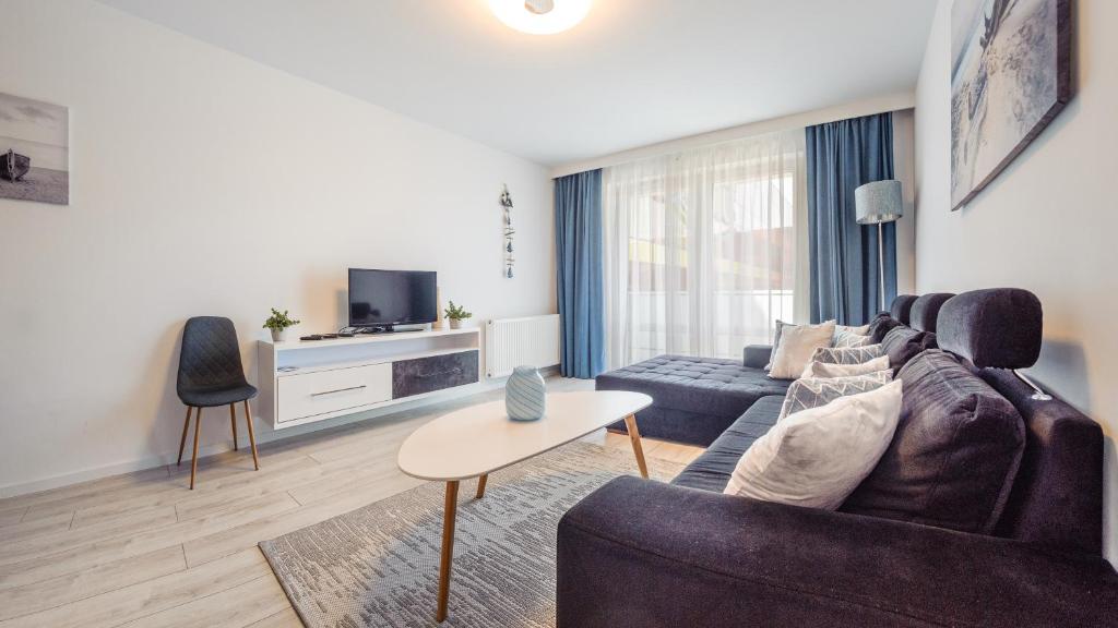 ein Wohnzimmer mit einem Sofa und einem TV in der Unterkunft Apartamenty Sun & Snow Aquarius in Kołobrzeg