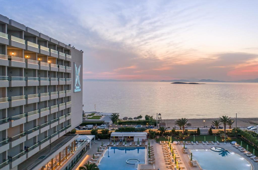 vista su un hotel con piscina e oceano di Divani Apollon Palace & Thalasso ad Atene