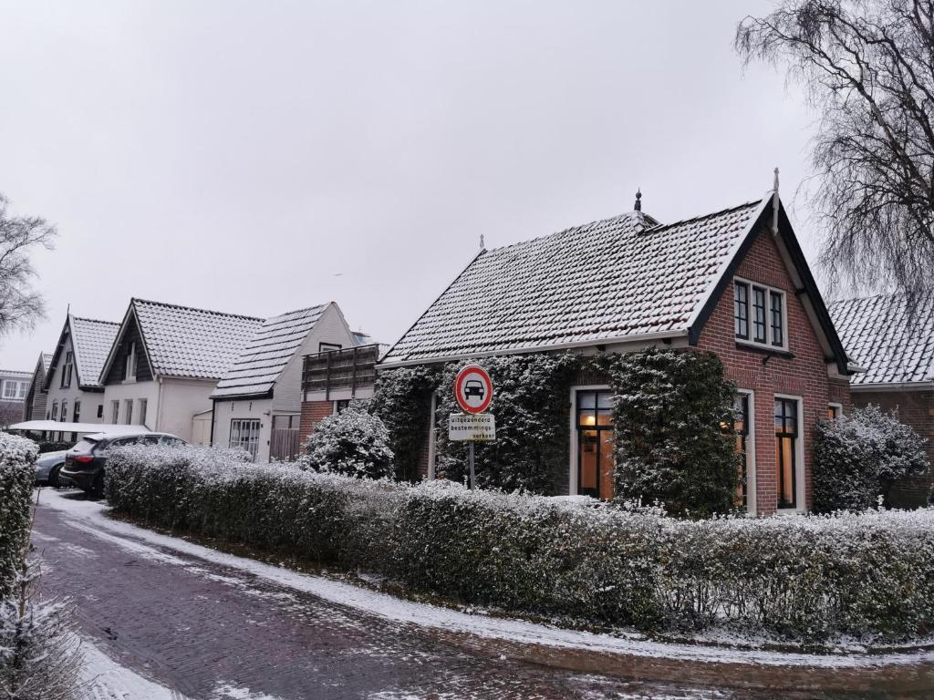 ein Haus ist mit Schnee bedeckt auf einer Straße in der Unterkunft Cottage Rose in Bergen