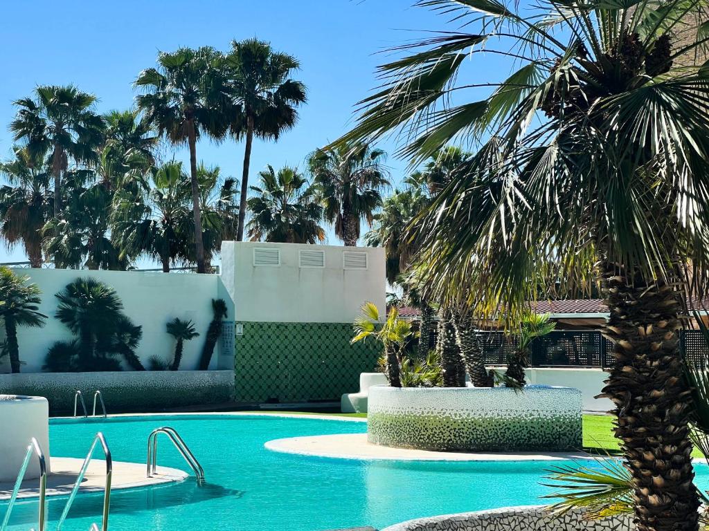 una piscina con una palmera en un complejo en Tropical y Lujoso Complejo, en Oropesa del Mar