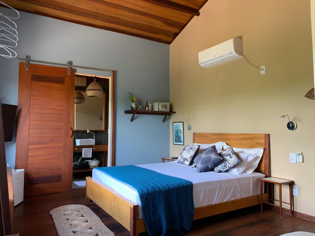 um quarto com uma cama com um cobertor azul em Vila das Águas em Atins