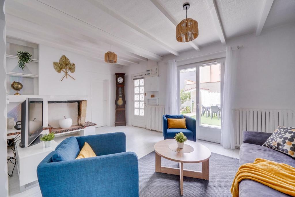 a living room with blue couches and a table at La Casa Bohème - Superbe maison avec parking privé in Bordeaux
