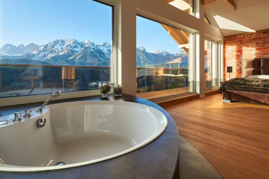 a large bath tub in a room with a large window at Panorama Chalet Fastenberg in Schladming