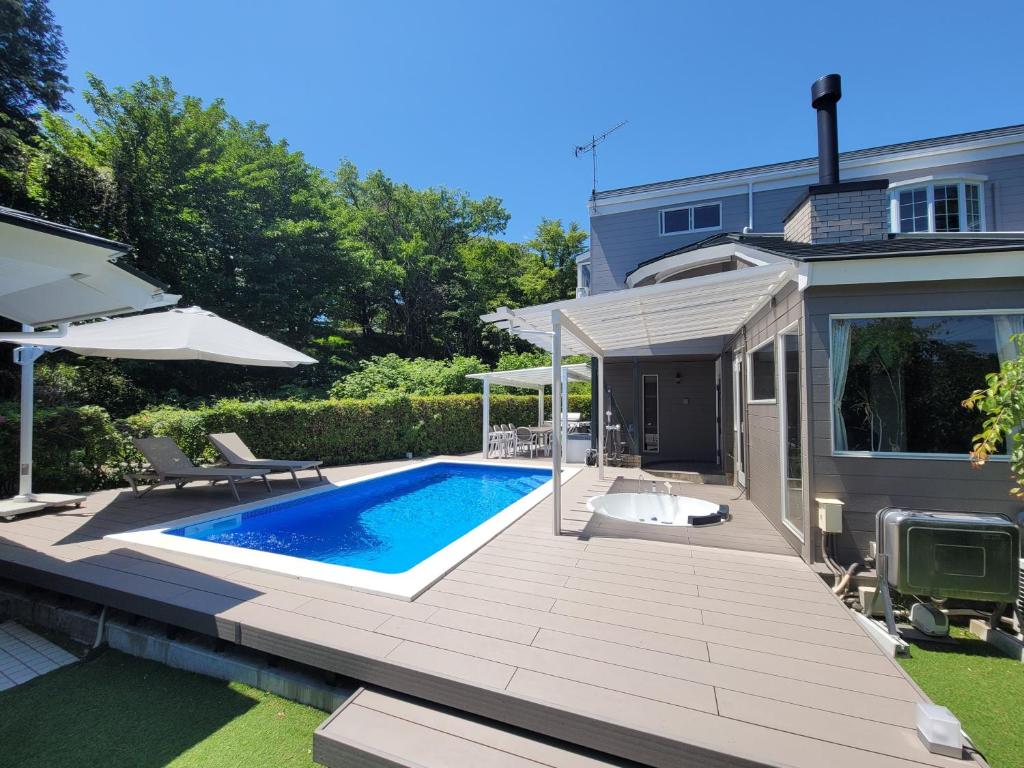 a backyard with a swimming pool and a house at フレッチア in Futo