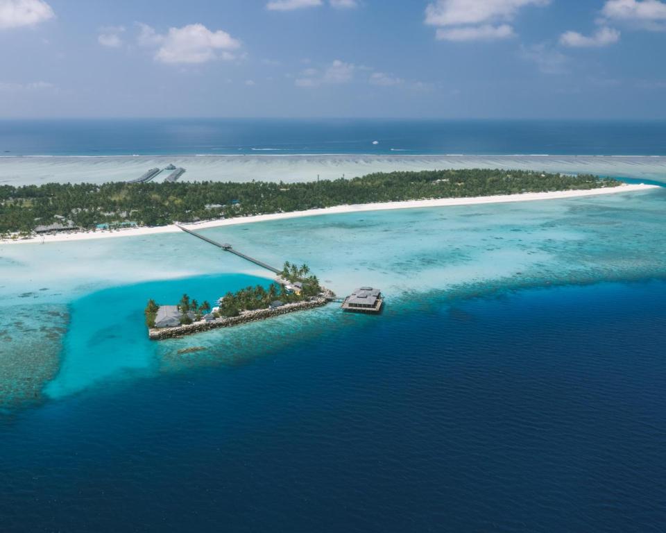 uma ilha no oceano com um barco na água em Villa Park Sun Island Resort em Maamigili