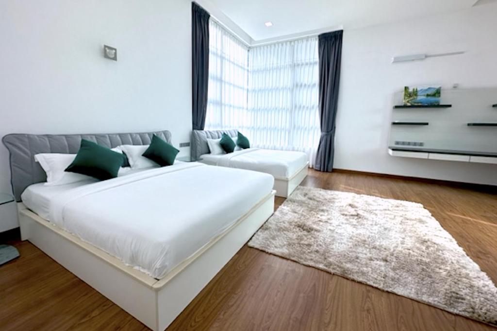 a bedroom with a large white bed and a rug at Teluk Cempedak Seventh Haven in Kuantan