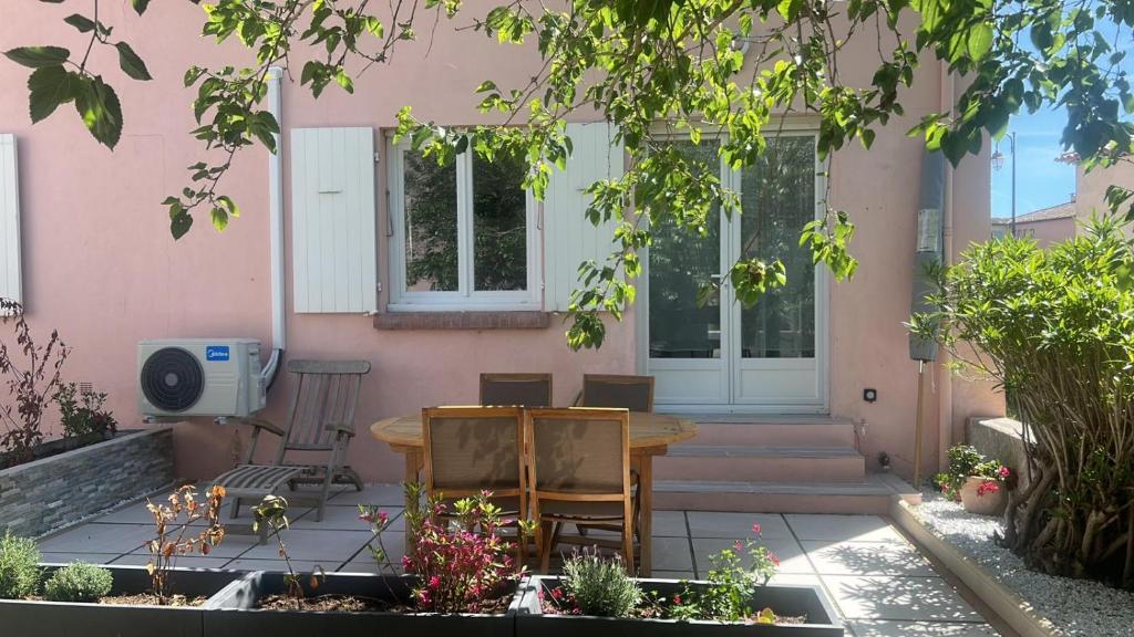 patio ze stołem przed różowym domem w obiekcie Le Beau site by Beds83 w Fréjus