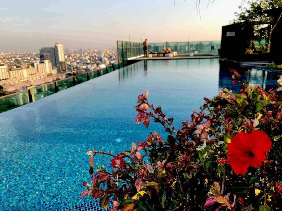 eine Blume am Rande eines Pools auf dem Dach eines Gebäudes in der Unterkunft HIGH RISE LUXURY CONDO 1BED ROOF TOP POOL 2 MinMRT in Bangkok