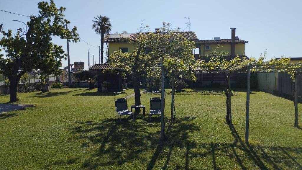 two chairs in a yard with trees and a house at Mansarda al mare in Pertegada