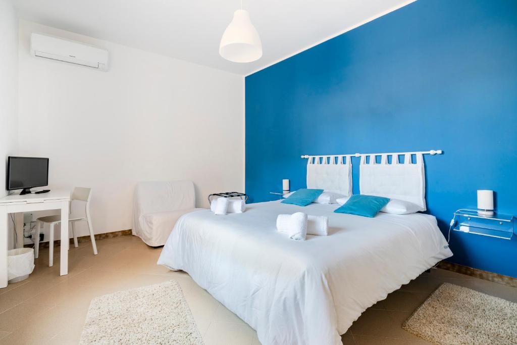 ein blaues Schlafzimmer mit einem weißen Bett und einer blauen Wand in der Unterkunft IL MONTE in Erice