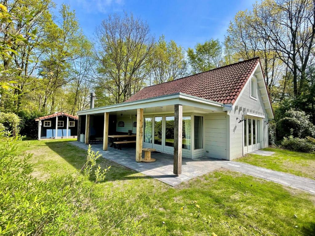 una pequeña casa blanca con patio en KempenLodge, luxe boshuis voor 8 pers, in Brabantse natuur en Diessen
