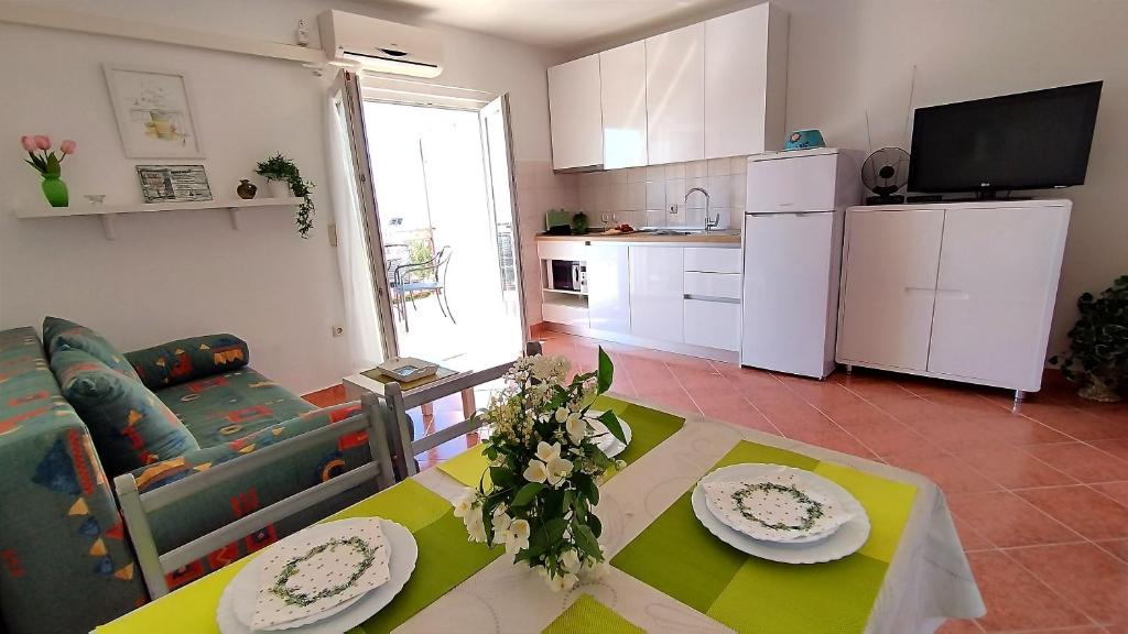 un soggiorno con tavolo e divano e una cucina di Apartment Anita a Trogir