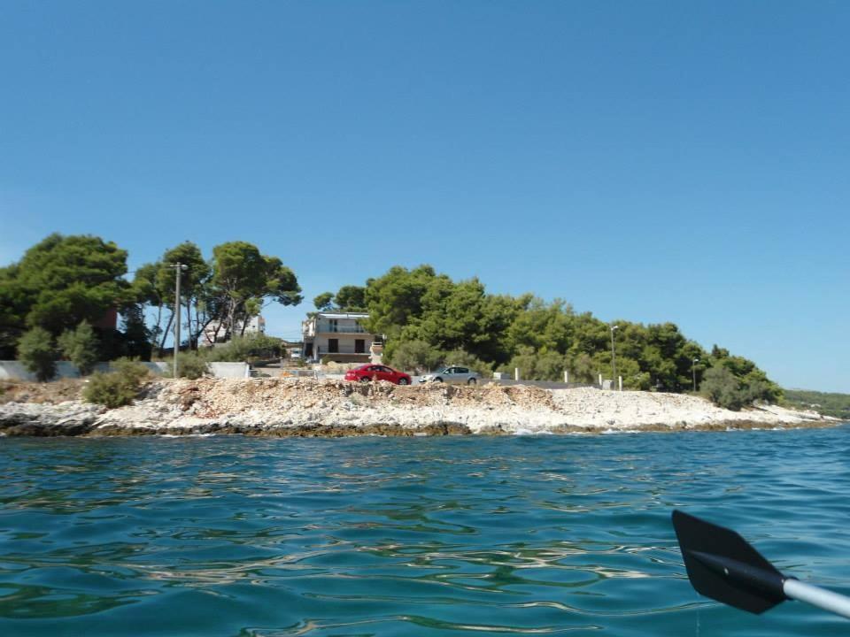 Apartment A. Žižić في سلاتين: قارب في الماء بجانب جزيرة صغيرة
