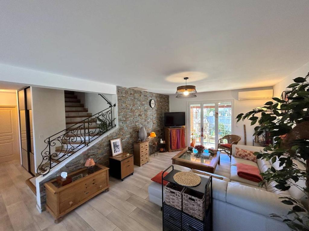 a living room with a couch and a staircase at Sublime Villa Climatisée Familiale avec Extérieurs Spacieux – Quartier Calme - FR-1-388-215 in Argelès-sur-Mer