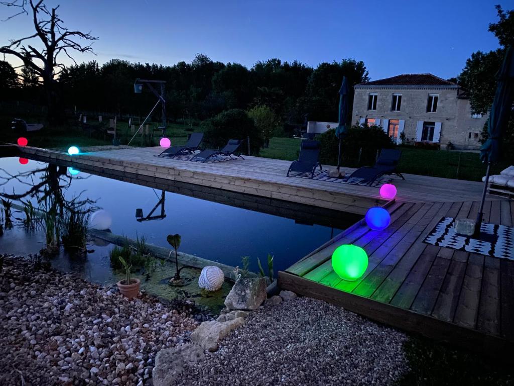 a backyard with a pool with balloons on a dock at Chambre d'hôte près Bordeaux in Bourg-sur-Gironde