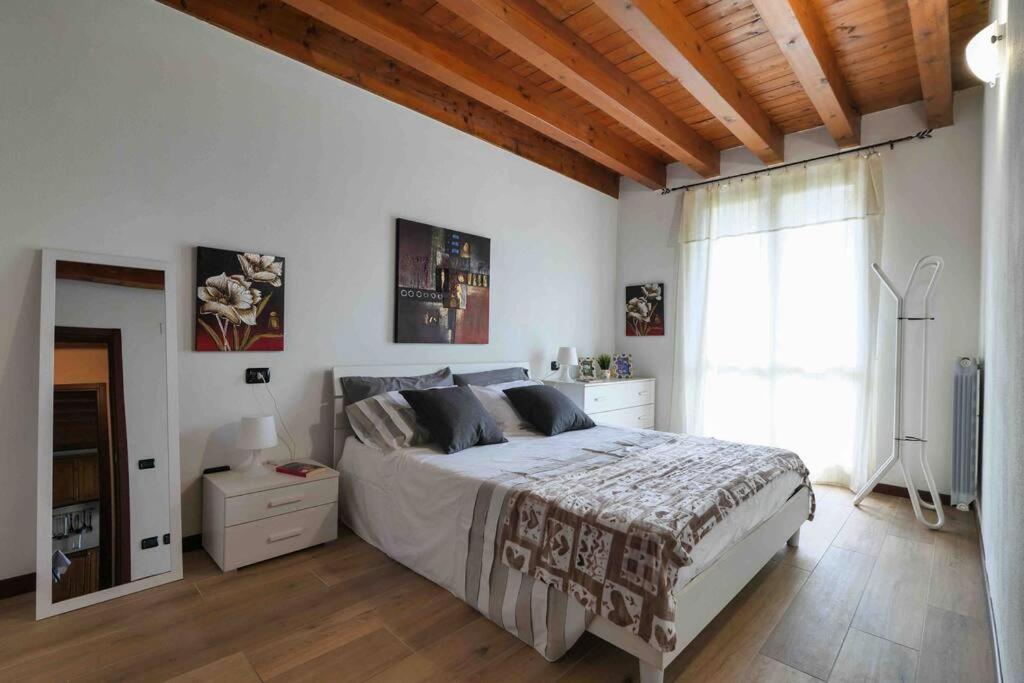 Centro storico Bilocale Check in 24h Wi-Fi Bus 500m في Borgo di Terzo: غرفة نوم بيضاء مع سرير كبير ونافذة