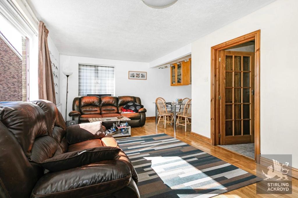 ein Wohnzimmer mit einem Ledersofa und einem Tisch in der Unterkunft Lux Homes in Sunbury Common