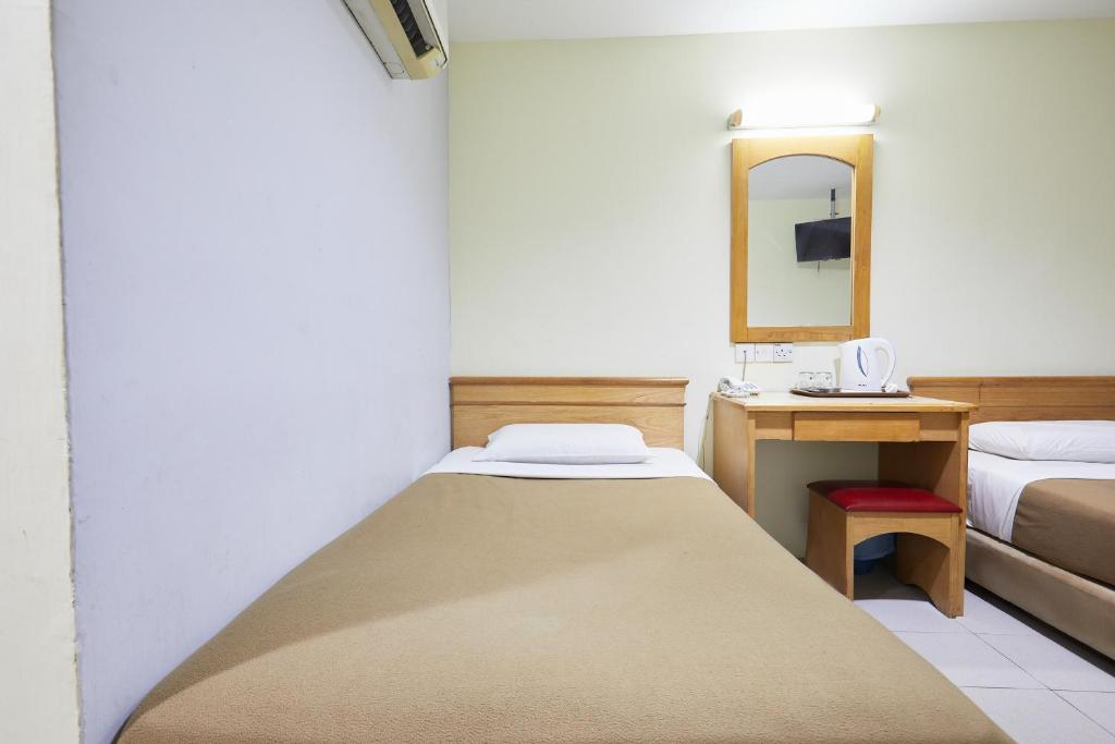 ein kleines Zimmer mit einem Bett und einem Spiegel in der Unterkunft Tang City Hotel at Petaling Street in Kuala Lumpur