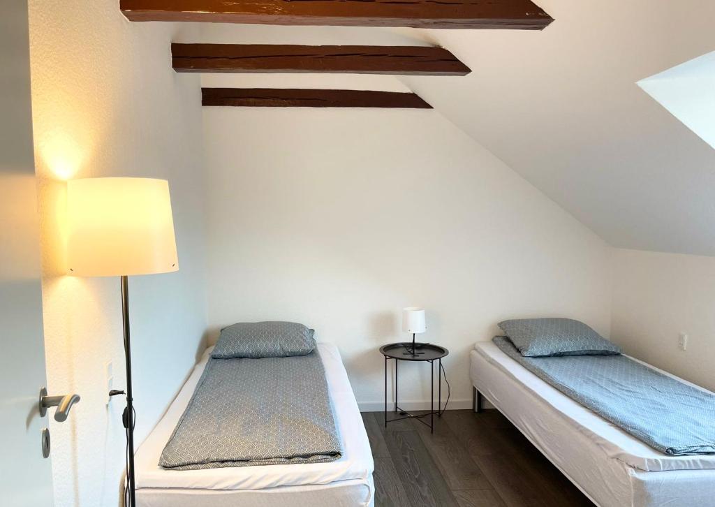 two beds in a room with a ceiling at Scandinavian Apartment Hotel - Lunden 1 - Central 3 bedroom apartment on two floors in Horsens