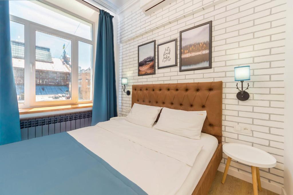 a bedroom with a bed and a table and a window at Scandinavian Apartments in Kyiv