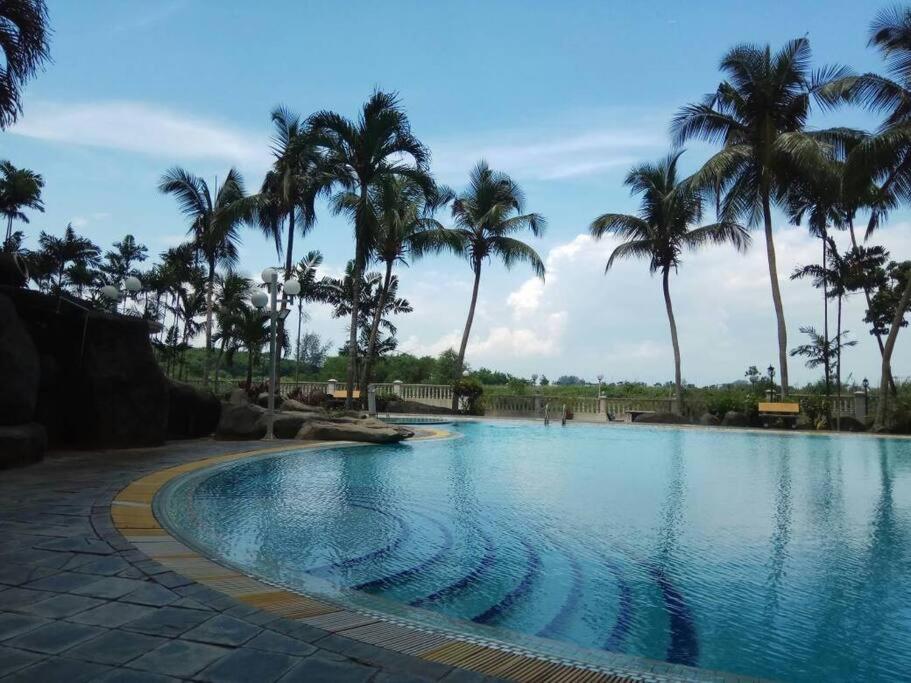 einen Pool mit Palmen in einem Resort in der Unterkunft Lagenda Condominium Melaka in Malakka