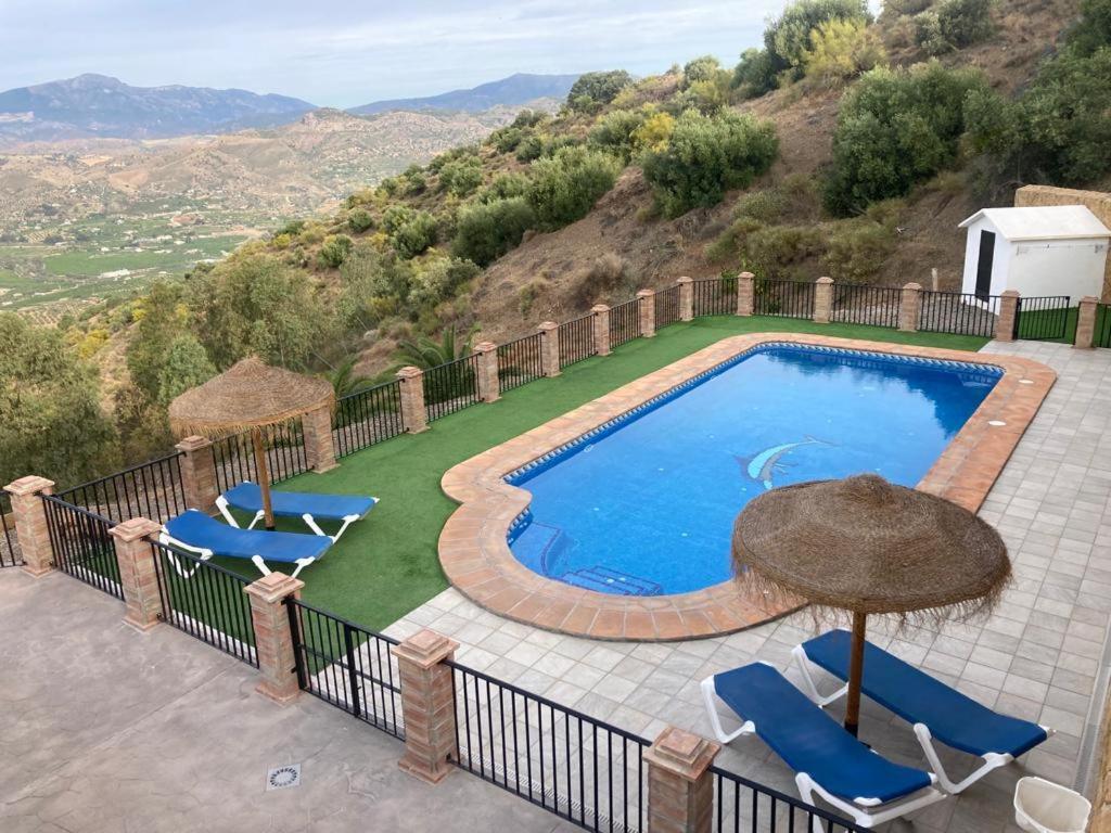 - une piscine avec des chaises et un parasol dans l'établissement Caminito del Rey , Álora Nice Views, à Alora