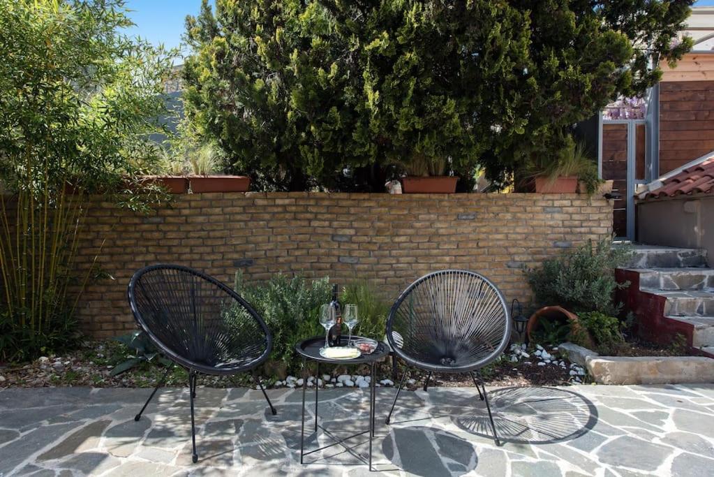twee stoelen naast een tafel met een wijnglas bij Nikas Guest House in Kanálion