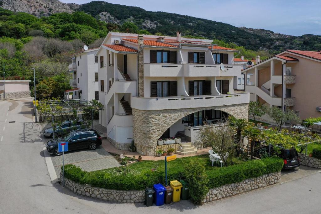 a building with a car parked in front of it at Apartments Andrea I in Baška