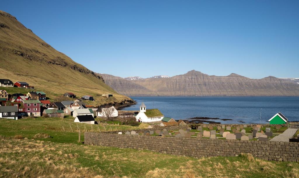 a small village on the side of a body of water at Lovely 4-BR house / Sea view / Nature in Oyndarfjørður
