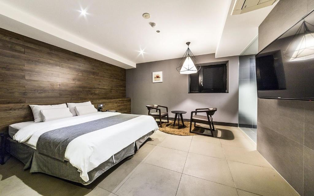 1 dormitorio con 1 cama grande y TV en Cherbourg Hotel, en Gwangmyeong